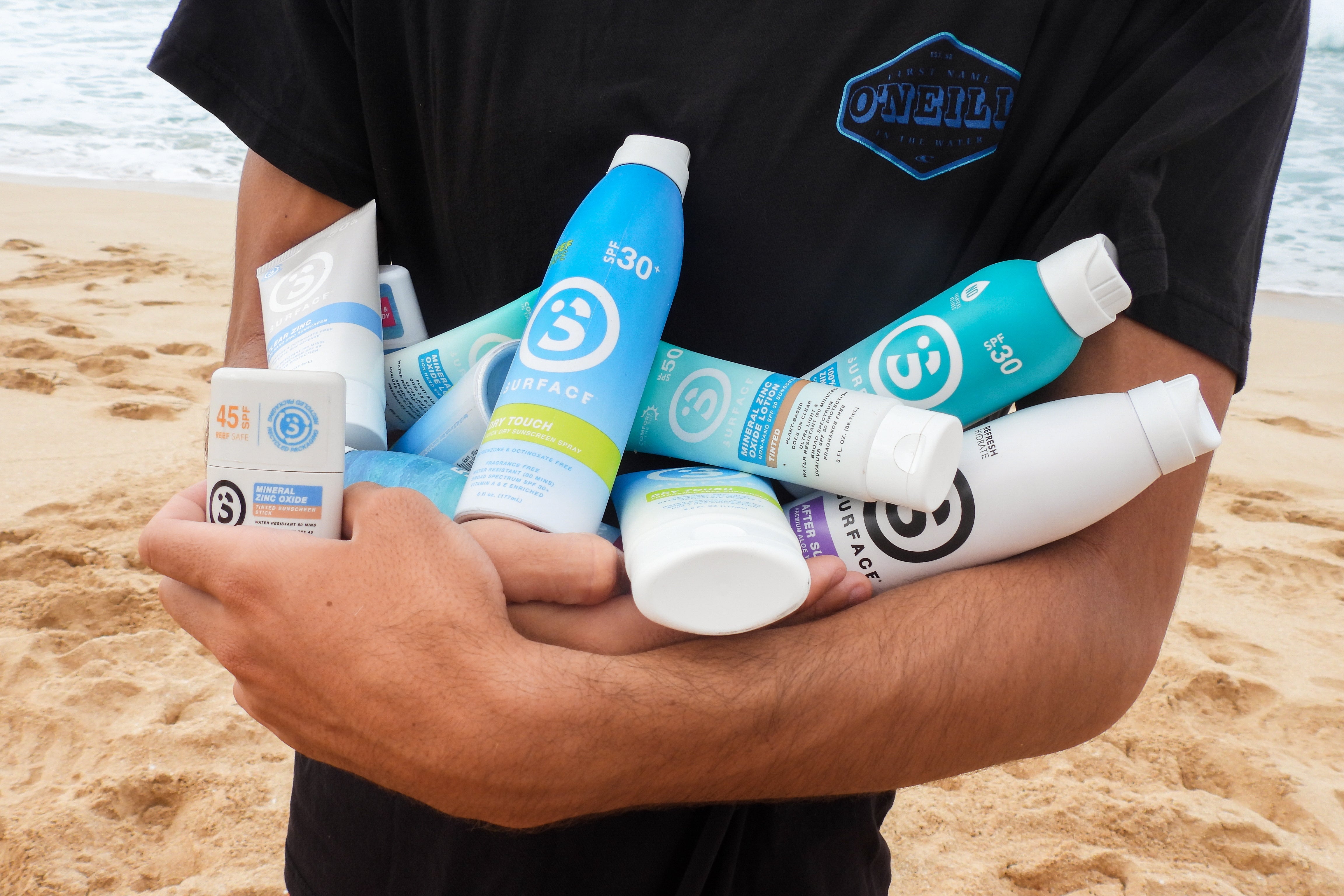 Man holding a bundle of sunscreens SPF 50 and 30