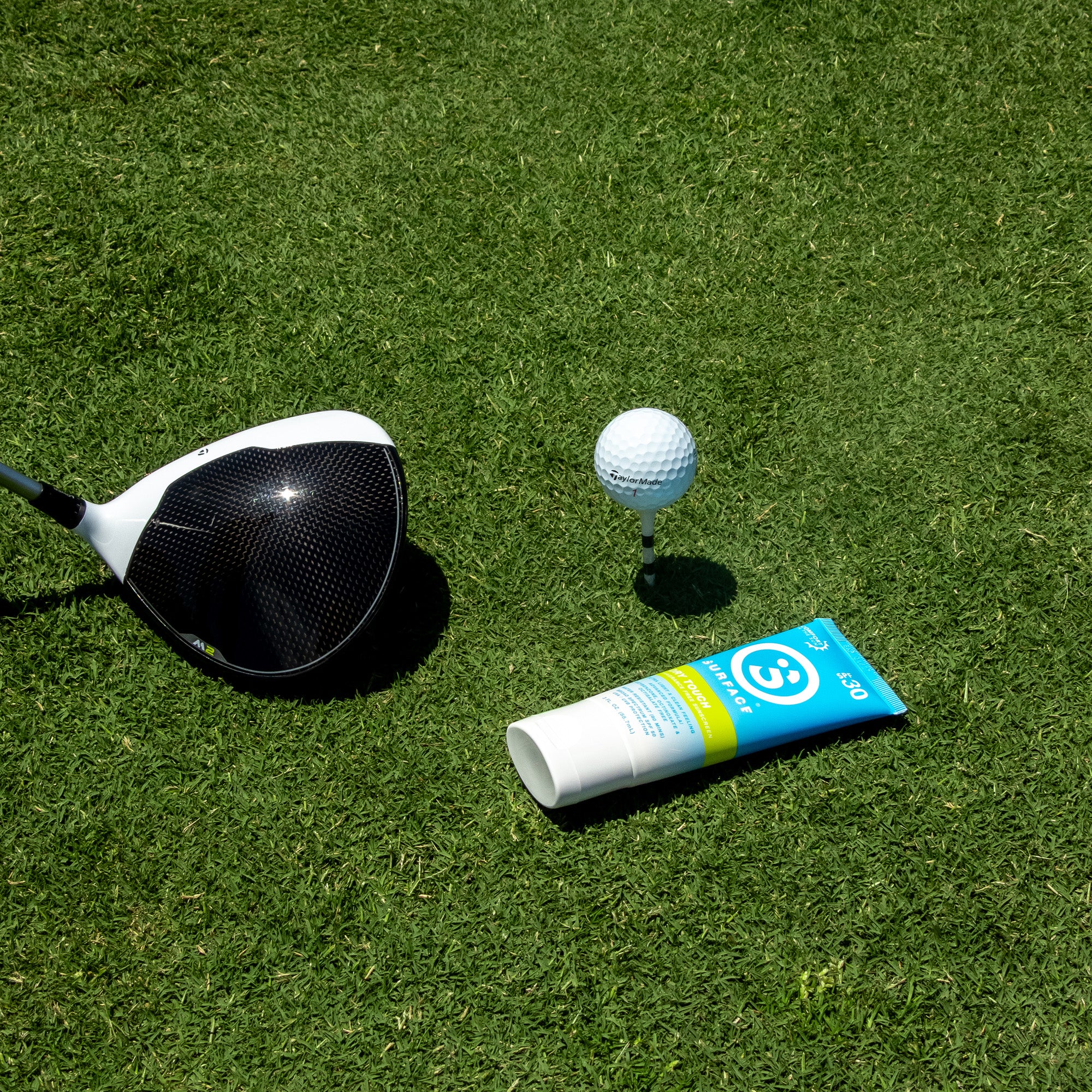 SPF30 Dry Touch Sunscreen Lotion 3oz. next to golf ball on tee and driver