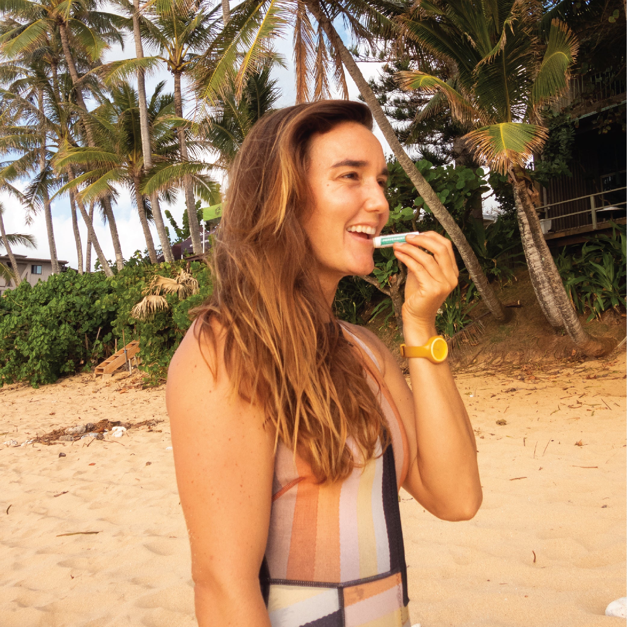Woman on the beach using peppermint lip balm