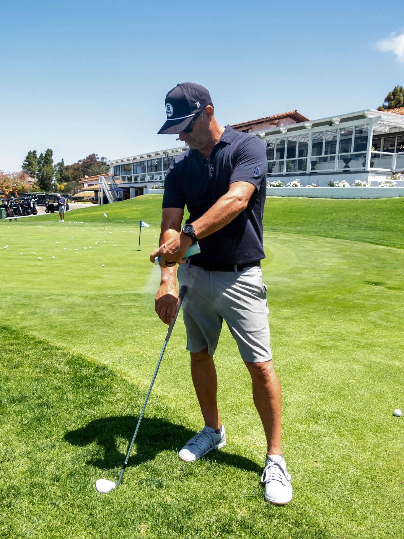 Golfer applying Surface Sunscreen dry touch spray