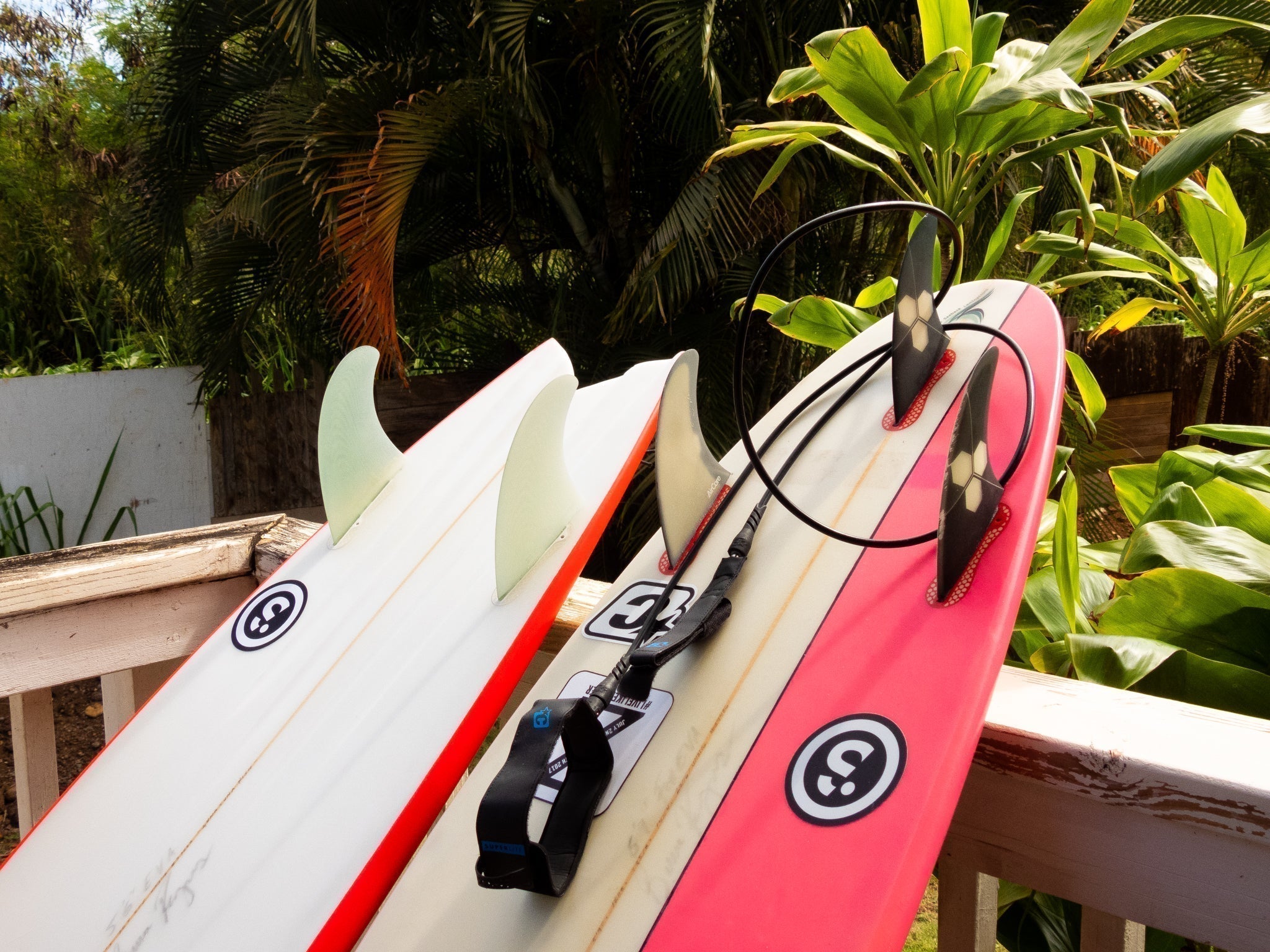 two surfboards leaning against a deck railing