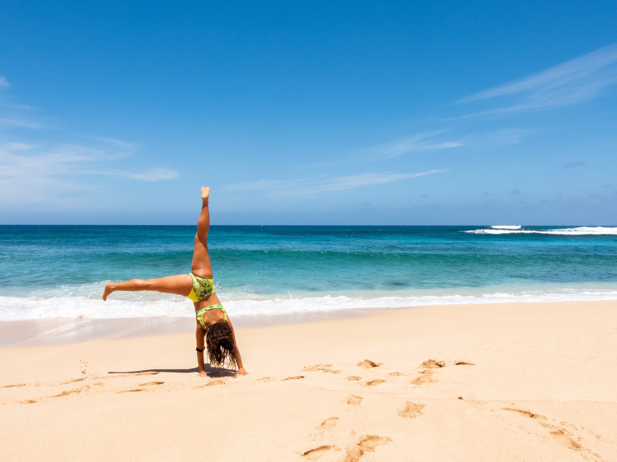Girl doing a cartwheel on a Hawaiian beach having fun