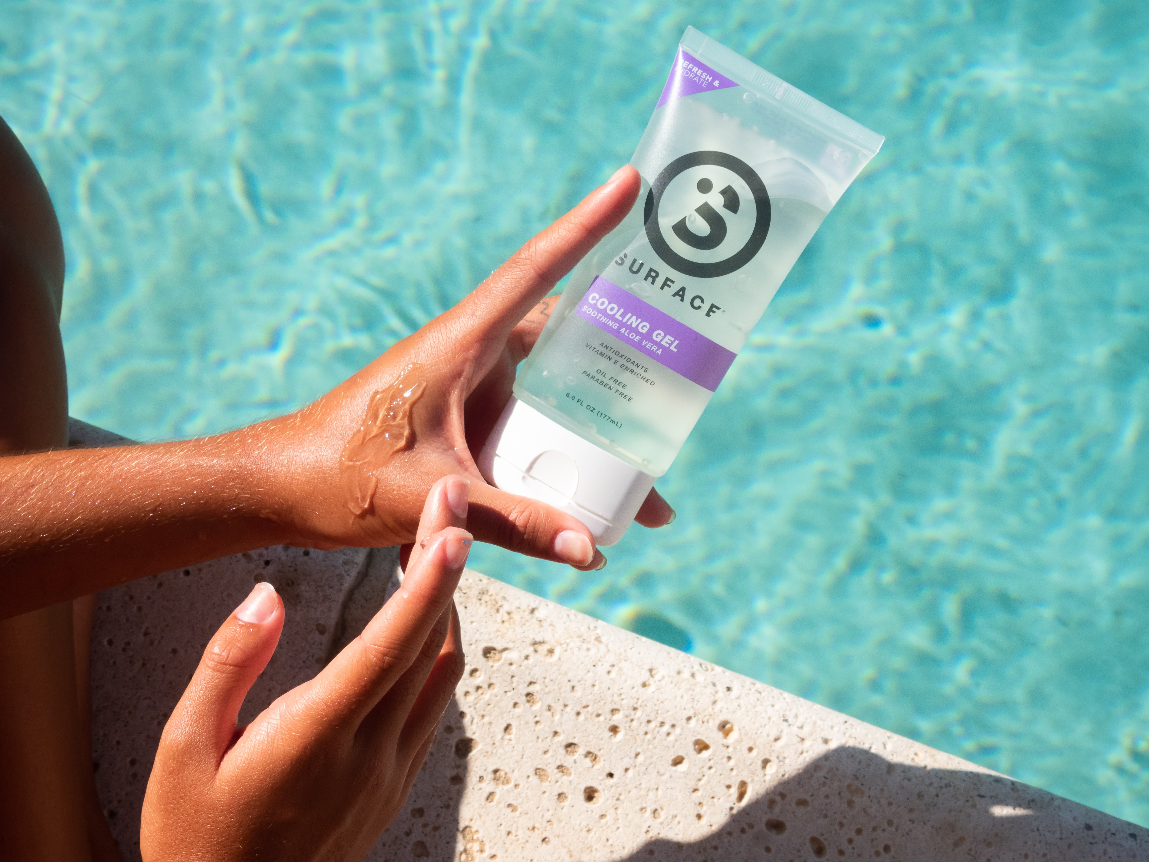Girl applying aloe vera gel next to a pool