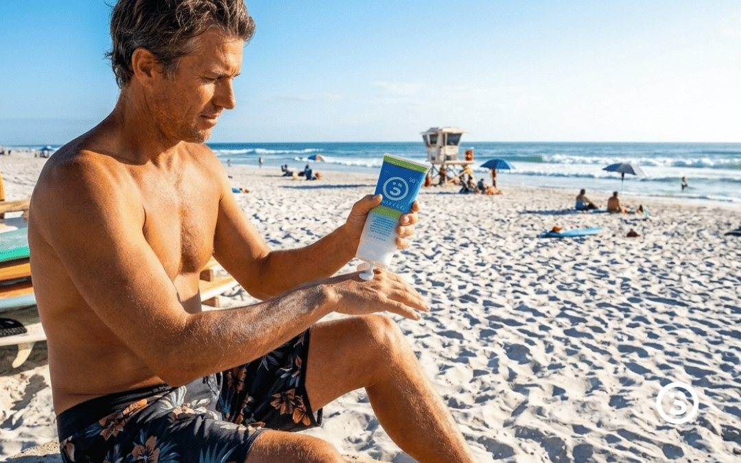 Surfer applying surface sunscreen dry touch lotion at the beach