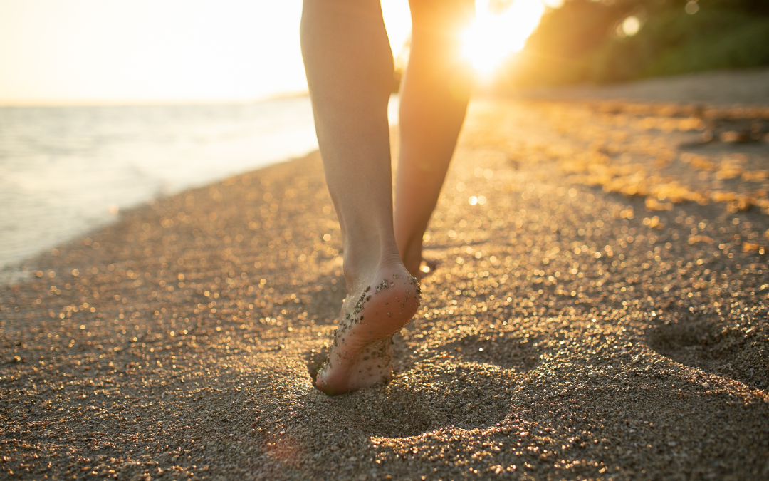 Woman walking on the beach at sunset